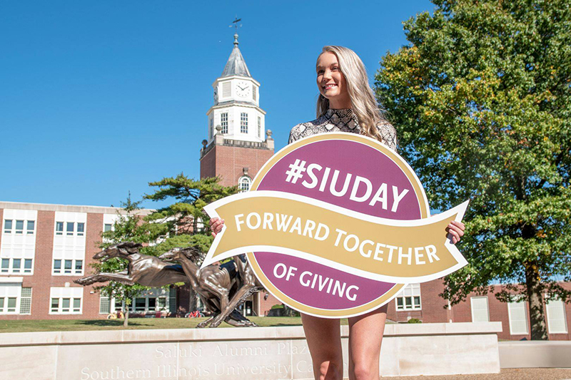 SIU Student holding a #SIUDAY of Giving Forward Together Sign